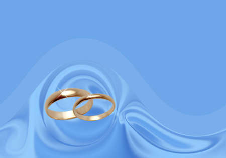 Wedding rings on blue material. Background for the invitation and congratulations wedding cardsの写真素材