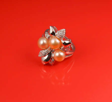 Jewelry pearl ring on red の写真素材