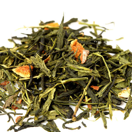 Green Tea with bits of orange on white backgroundの写真素材