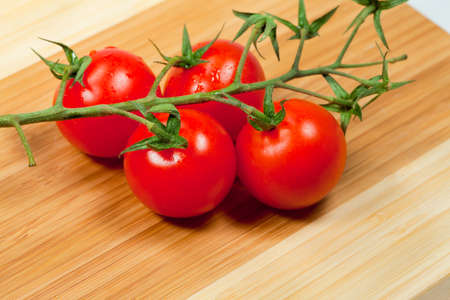  Tomato cherry on  green  branch on wooden boardの写真素材