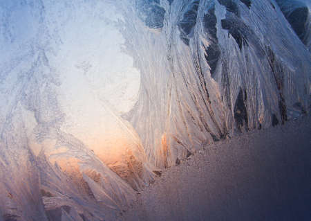 Frosty natural pattern at a winter window glass
の写真素材