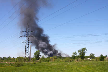 Fire in a field, a column of a dense black smokeの写真素材