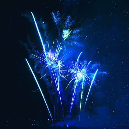 Blue firework in background of night sky 