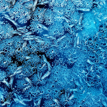 Frosty winter pattern at a window glass, macro textureの写真素材