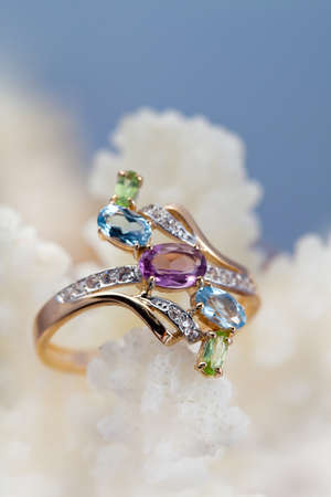 Golden  ring with topaz, amethyst, brilliants on coral reef