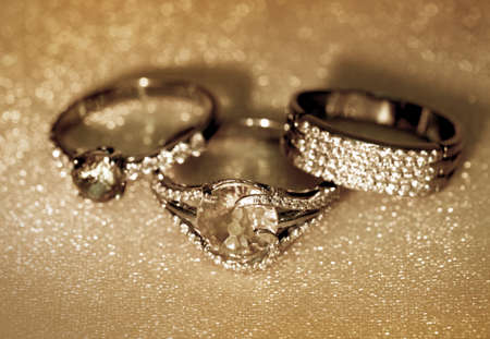 Golden jewelry accessories - rings with brilliants on golden backgroundの写真素材