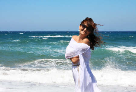  The beautiful girl at the sea in white developing clothes on a sea-breezeの写真素材