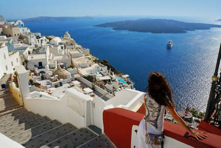 Beautiful woman on holidays, Santorini Thira town view