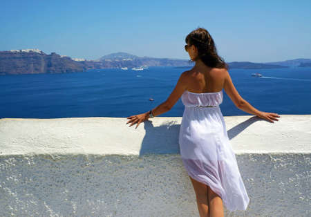Beautiful woman on holidays, Santorini Thira town viewの写真素材