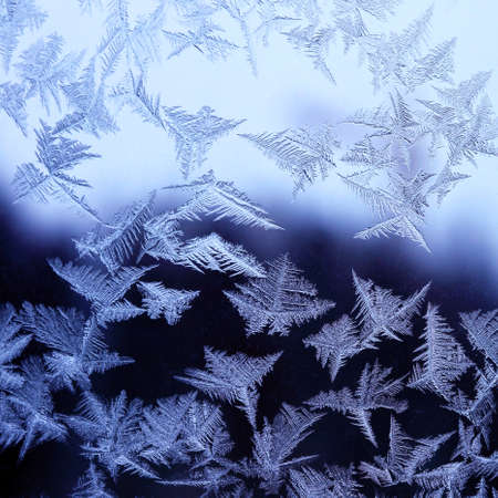 Frosty winter pattern at a window glass, macro texture
