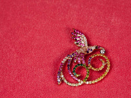 Golden jewelry brooch bird on pink background for valentines cardsの写真素材