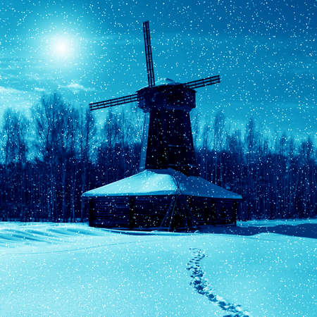Winter nature, night, wooden mill and snowstorm and moonの写真素材