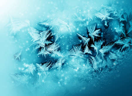 Frosty cold pattern at a winter window glassの写真素材