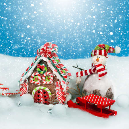 Christmas decoration in snow,  sweet house and snowmanの写真素材