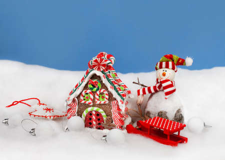 Christmas decoration in snow,  sweet house and snowmanの写真素材