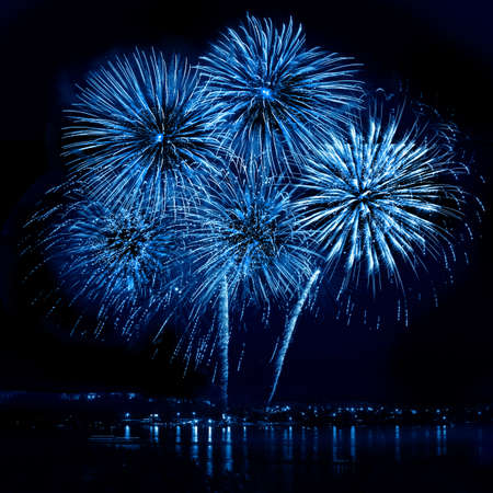 Celebratory blue firework in a night sky の写真素材