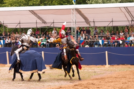 Moscow, Russia - June 23, 2013: Times and Epoch-2013 festival in Kolomenskoye park. The Middle Ages (Srednevekove). Two Knights fighting on the swords on a horse in a historical reconstruction on the joust.のeditorial素材