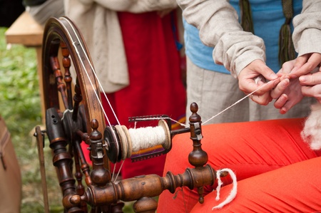 spinning-wheel with hands making yarn from the woolの写真素材