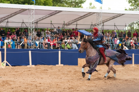 MOSCOW - JUNE 22, 2013 - Times and Epoch festival in the Kolomenskoye. The Middle Ages. - Unidentified horseman galloping on a stallion covered in ceremonial armor in a historical reconstruction.のeditorial素材