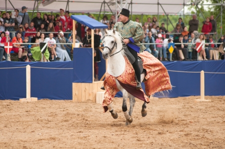 MOSCOW - JUNE 22, 2013 - Times and Epoch festival in the Kolomenskoye. The Middle Ages. - Unidentified horseman galloping on a white stallion covered in ceremonial armor in a historical reconstruction.のeditorial素材