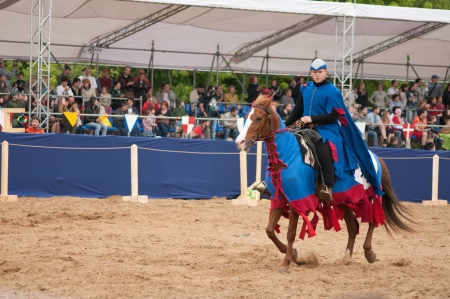 MOSCOW - JUNE 22, 2013 - Times and Epoch festival in the Kolomenskoye. The Middle Ages. - Unidentified horseman galloping on a bay stallion covered in ceremonial armor in a historical reconstruction.のeditorial素材