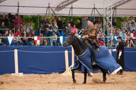 MOSCOW - JUNE 22, 2013 - Times and Epoch festival in the Kolomenskoye. The Middle Ages. - Unidentified horseman galloping on a black stallion covered in ceremonial armor in a historical reconstruction.のeditorial素材