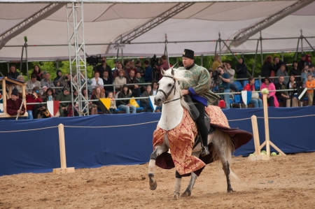 MOSCOW - JUNE 22, 2013 - Times and Epoch festival in the Kolomenskoye. The Middle Ages. - Unidentified horseman galloping on a white stallion covered in ceremonial armor in a historical reconstruction.のeditorial素材