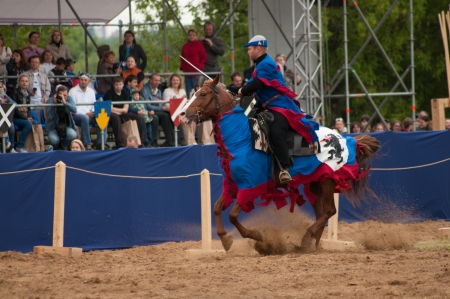 MOSCOW - JUNE 22, 2013 - Times and Epoch festival in the Kolomenskoye. The Middle Ages. - Unidentified horseman galloping on a bay stallion covered in ceremonial armor in a historical reconstruction.のeditorial素材