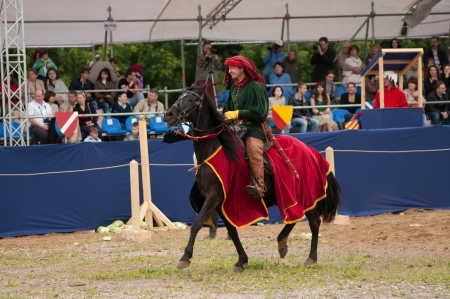 MOSCOW - JUNE 22, 2013 - Times and Epoch festival in the Kolomenskoye. The Middle Ages. - Unidentified horseman galloping on a black stallion covered in ceremonial armor in a historical reconstruction.のeditorial素材