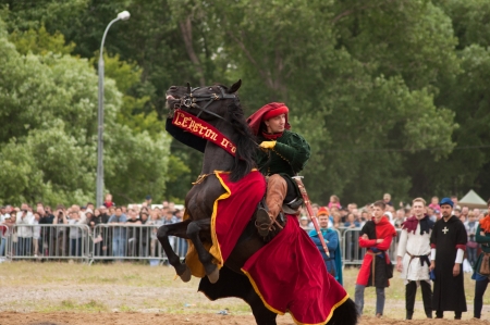 MOSCOW - JUNE 22, 2013 - Times and Epoch festival in the Kolomenskoye. The Middle Ages. - Black stallion rearing with an unidentified horseman on its back in a historical reconstruction.のeditorial素材