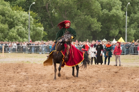 MOSCOW - JUNE 22, 2013 - Times and Epoch festival in the Kolomenskoye. The Middle Ages. - Unidentified horseman galloping on a black stallion covered in ceremonial armor in a historical reconstruction.のeditorial素材