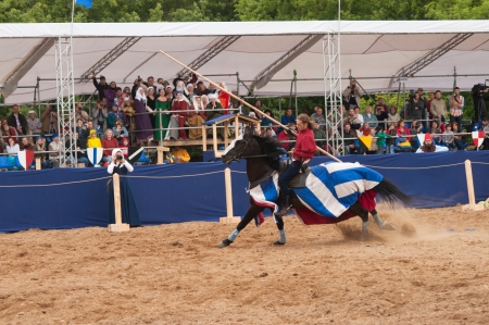 MOSCOW - JUNE 22, 2013 - Times and Epoch festival in the Kolomenskoye. The Middle Ages. - Unidentified horseman galloping on a black stallion covered in ceremonial armor in a historical reconstruction.のeditorial素材