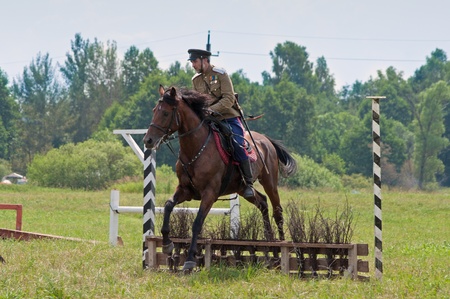 MOSCOW REGION, DUSHONOVO - JULY 6, 2013 - dushonovskiye maneuvers festival in the Dushonovo village, Moscow Region. - Unidentified horseman jumping over barrier on a bay stallion in a historical reconstruction.のeditorial素材