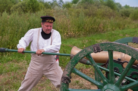 MOSCOW REGION, DUSHONOVO - JULY 6, 2013 - dushonovskiye maneuvers festival in the Dushonovo village, Moscow Region. - Unidentified man cleaning cannon by a ramrod in a historical reconstruction.のeditorial素材