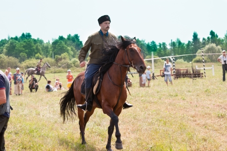 MOSCOW REGION, DUSHONOVO VILLAGE, RUSSIA â JULY 6 2013: Dushonovskiye maneuvers festival. Unidentified horseman wearing old military uniform galloping on a bay stallion in a historical reconstruction.のeditorial素材