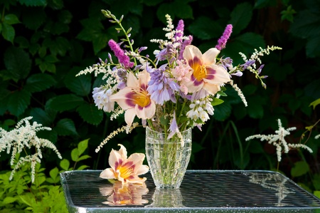 still life bouquet with hemerocallis in a dark green leaves backgroundの写真素材