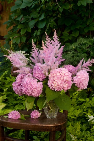 Still life bouquet with pink hydrangea and astilba on the old chairの写真素材