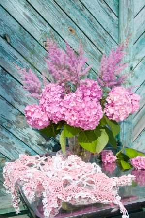 Still life bouquet with pink hydrangea and astilba with homemade crochet tableclothの写真素材
