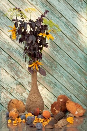 basil and cone flowers in a vintage vase with mushrooms still lifeの写真素材