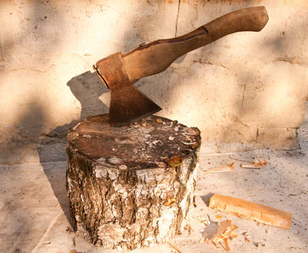 axe on the stumb in a sunny day with shadowの写真素材