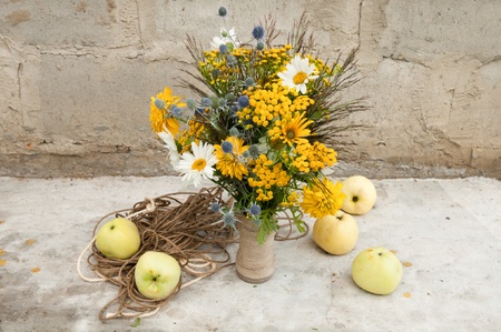 still life with wild flowers bouquet and white transparent applesの写真素材