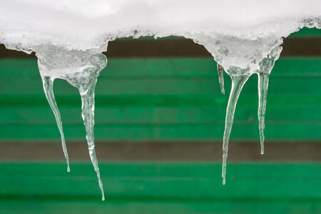 two group of icicles on the green wall background