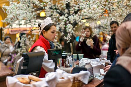 MOSCOW - MARCH 22: A buyer choosing a baking in the GUM store on March 22, 2015 in Moscow. GUM is the large store facing Red Square. It is popular among international tourists.のeditorial素材