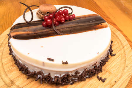 Sponge cake with cream cheese, chocolate and fresh red currants berriesの写真素材