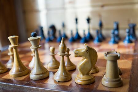 Old Craved wooden Chess pieces on a Boardの写真素材