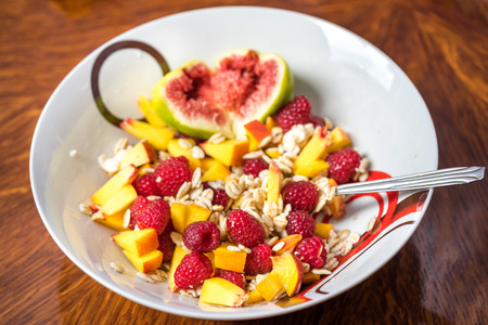 Healthy homemade oatmeal with berries and fig in a shape of heart for organic breakfast.の写真素材