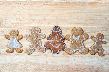 gingerbread homemade figures of four people together with christmas tree in the middle of a group on...