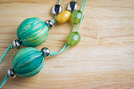 green hand made necklace on wooden background with copy space for your textの写真素材