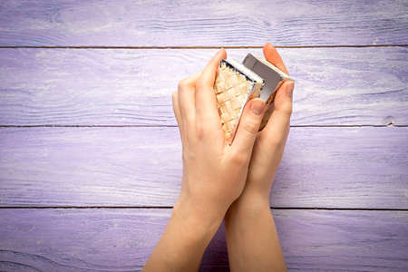 A female hands hold a small box with present on the wooden desk top view with copy spaceの写真素材