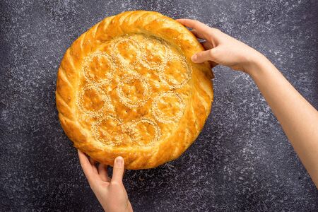 Woman hands holding tasty fresh bread, top view